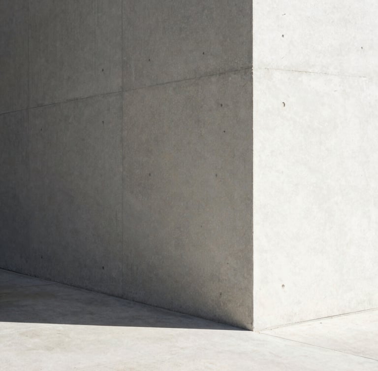 Minimalist architectural concrete corner under harsh sunlight, sharp diagonal shadow, clean geometric lines.