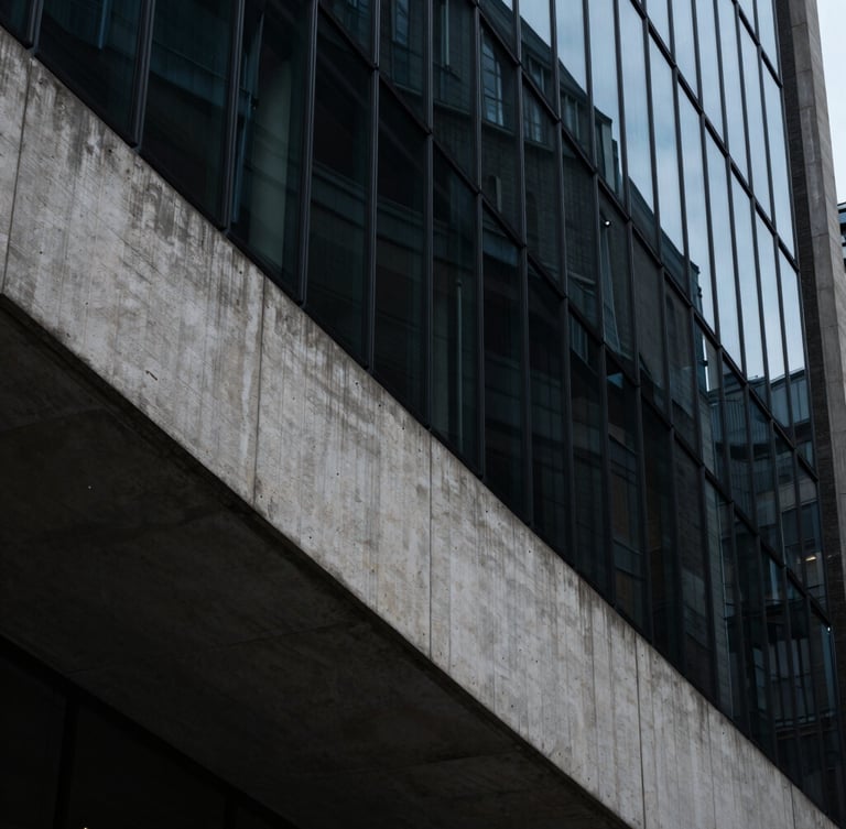 Extreme wide-angle shot of a brutalist concrete and glass facade in London, sharp diagonal shadows, cool ambient light, high contrast