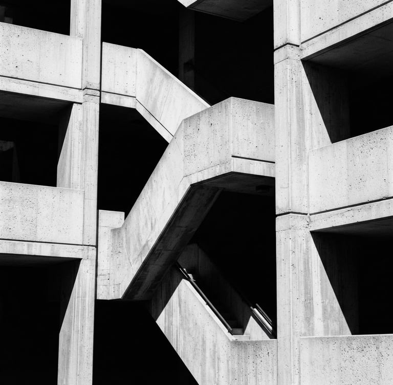 Stark monochromatic architectural crop, sharp concrete angles and deep shadows, high-contrast natural light, editorial 35mm photography