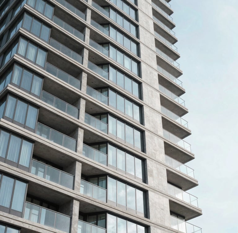Low-angle architectural photography of a modern luxury residential high-rise with clean glass and concrete facades in Las Condes, bright crisp morning daylight, cool desaturated tones, sharp focus, 35mm