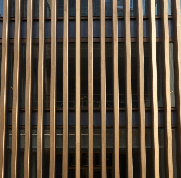 A close-up of a structured bronze facade with clean vertical lines, warm sand tones, indirect natural daylight, reflecting stability and order, 35mm.