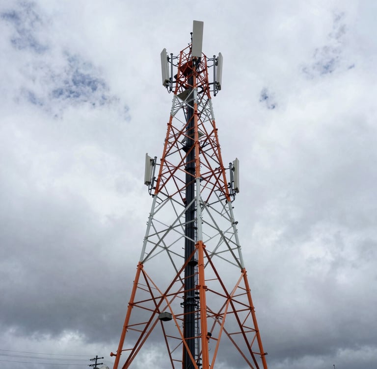 Wide-angle industrial engineering photography of a massive telecommunications tower against dramatic overcast Andean skies, high-contrast cool steel tones with subtle safety orange accents.