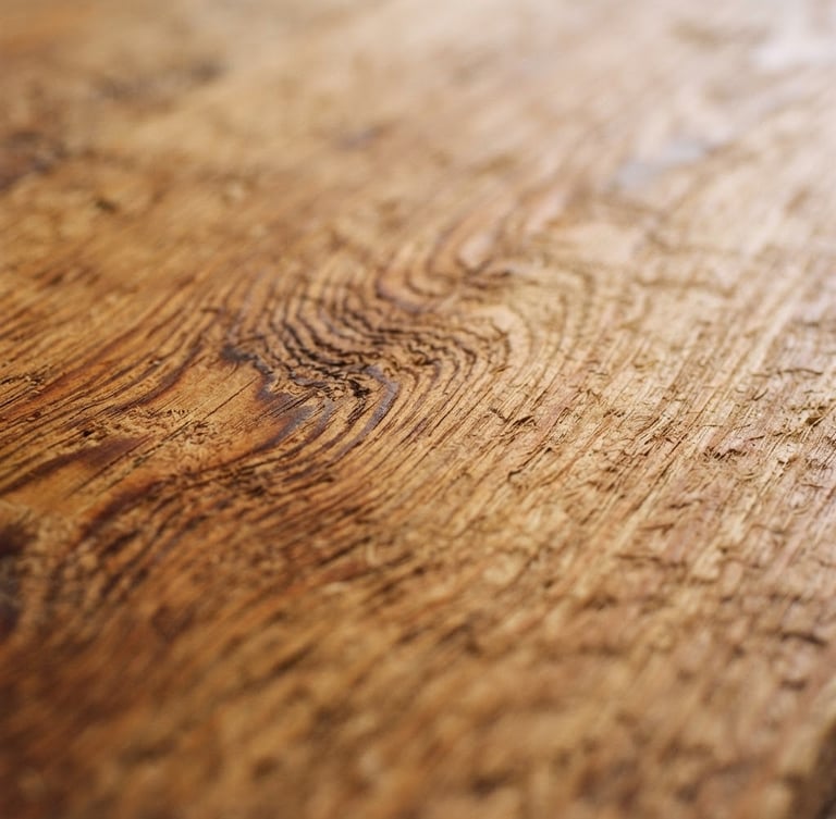 Macro detail shot of a hand-planed Douglas fir timber surface, soft overcast Pacific Northwest window light, rich natural wood grain, shallow depth of field, 35mm
