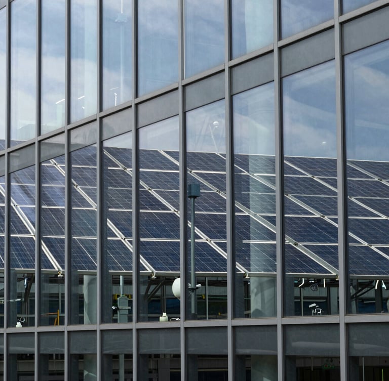 Crisp architectural close-up of a modern research facility glass facade reflecting a clean energy array, cool daylight, sharp focus