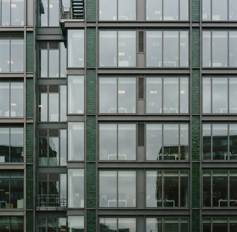 Architectural crop of a modern office building facade in Fitzrovia, London, overcast daylight, crisp lines, deep green accents, 35mm editorial film photography.