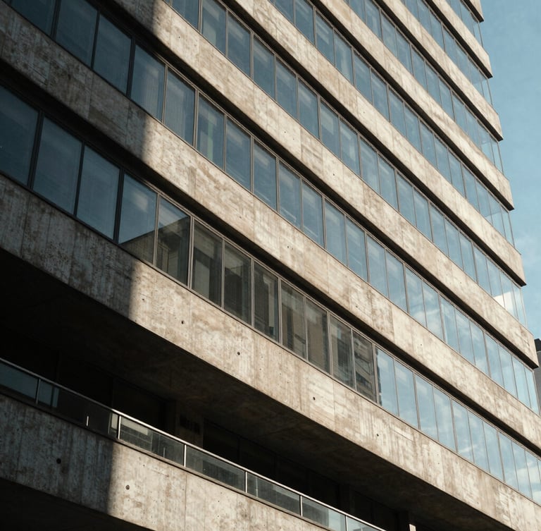Wide architectural crop of modern concrete and glass building facade in São Paulo, sharp geometric shadows, bright natural daylight.