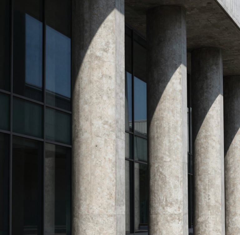 Dramatic architectural geometry of concrete columns and glass panels, sharp shadows, high contrast