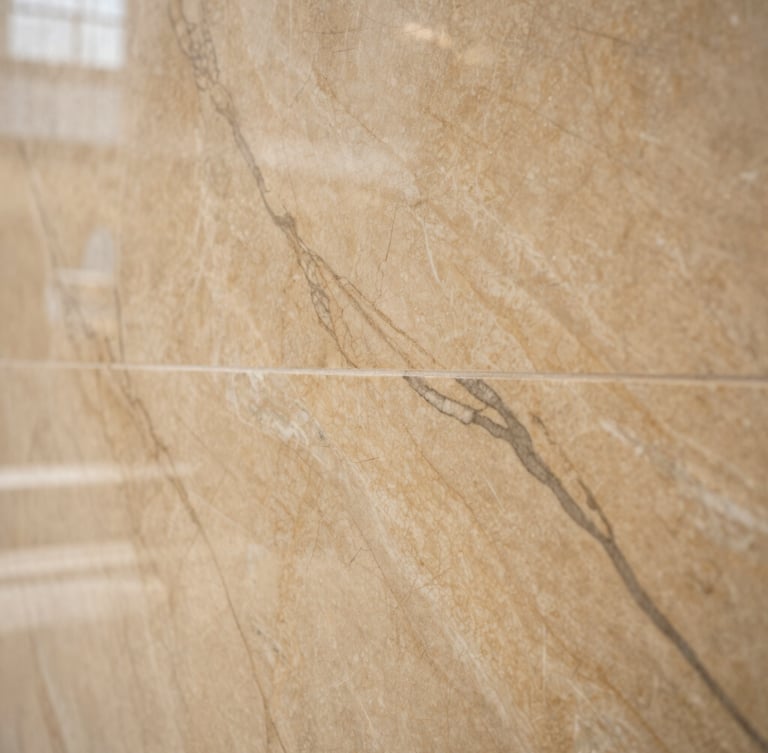 Detailed close-up of premium bookmatched marble veins on a wall, warm sand tones, architectural interior detail, soft natural light, sharp focus