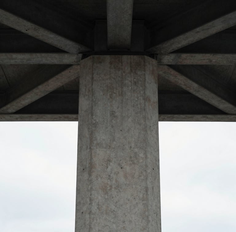 Symmetrical vertical crop of a modern concrete column meeting a dark steel ceiling beam, natural overcast light