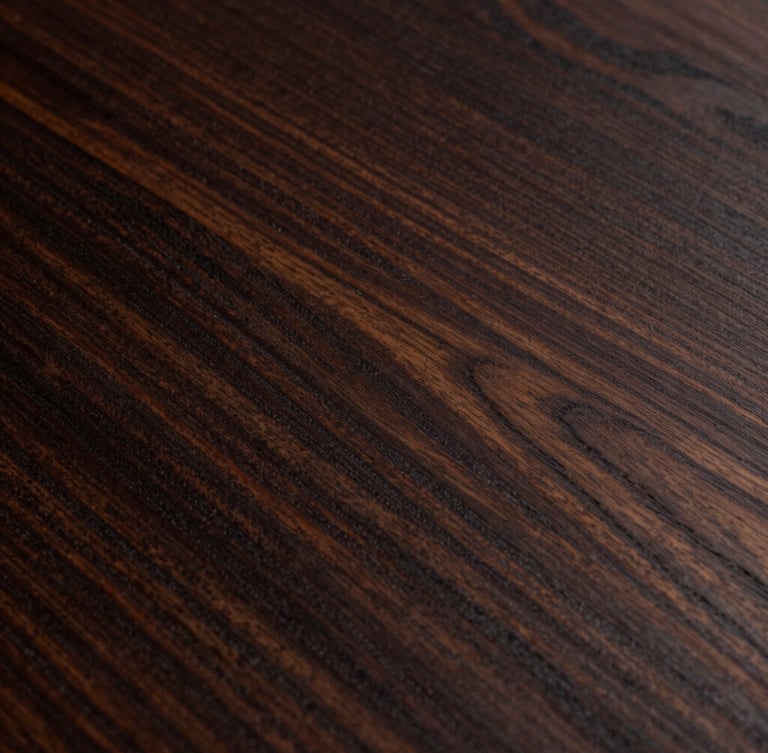 Extreme close-up of dark mahogany wood grain with deep natural shadows, reflecting low side-light, showcasing rich organic textures.