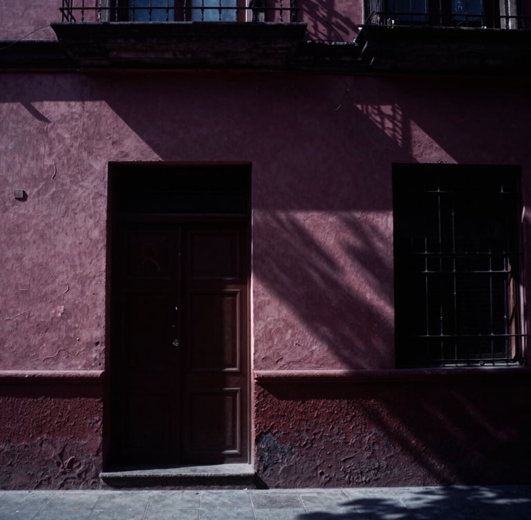 Moody film photography of a high-contrast CDMX film set, soft natural light, deep plum shadows, cinematic 35mm