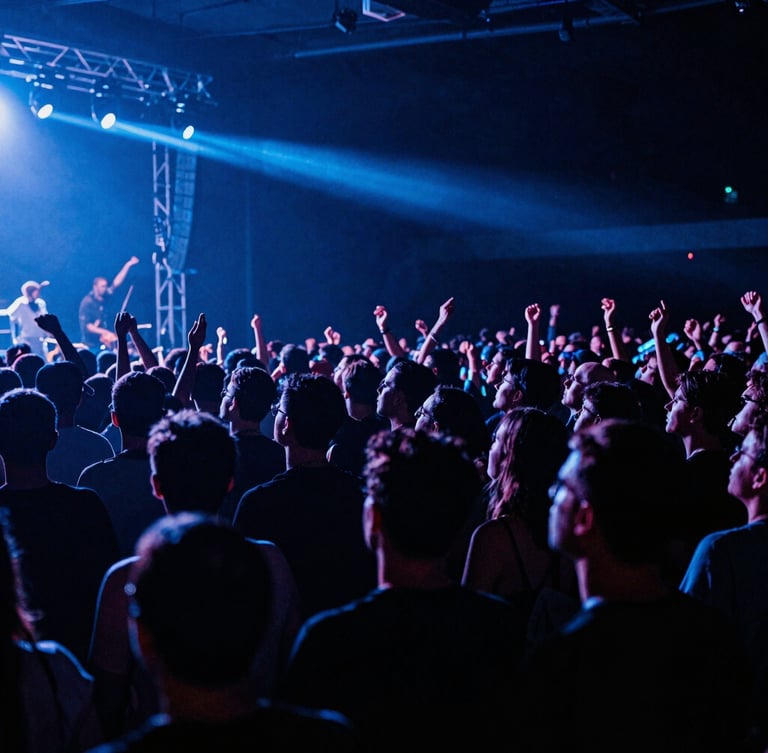 A dramatic wide-angle shot of a live concert crowd under intense blue stage lights, heavy shadows, raw energy, high-contrast.