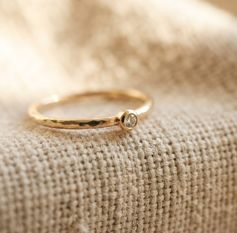 Macro photograph of a delicate gold ring resting on textured linen, soft warm morning light, shallow depth of field