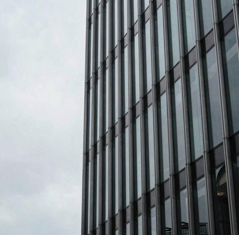 Tight architectural detail of a steel-and-glass curtain wall in the City of London, overcast sky, cool desaturated tones, sharp 35mm lens.