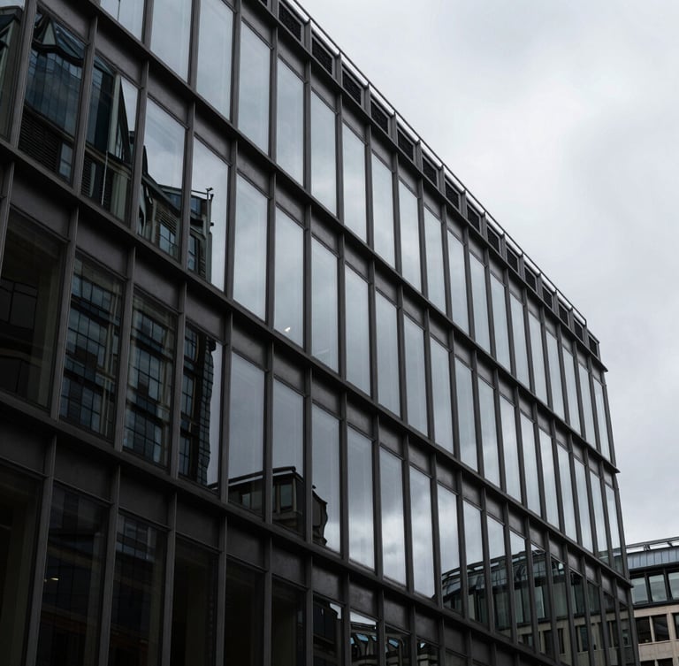 Steel-and-glass curtain wall of a City of London commercial building, reflecting overcast sky, high-contrast architectural geometry, deep shadows.
