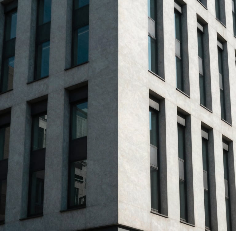 Sharp architectural angle of a modern minimalist corporate building facade under cool, high-contrast indirect daylight, casting geometric shadows.