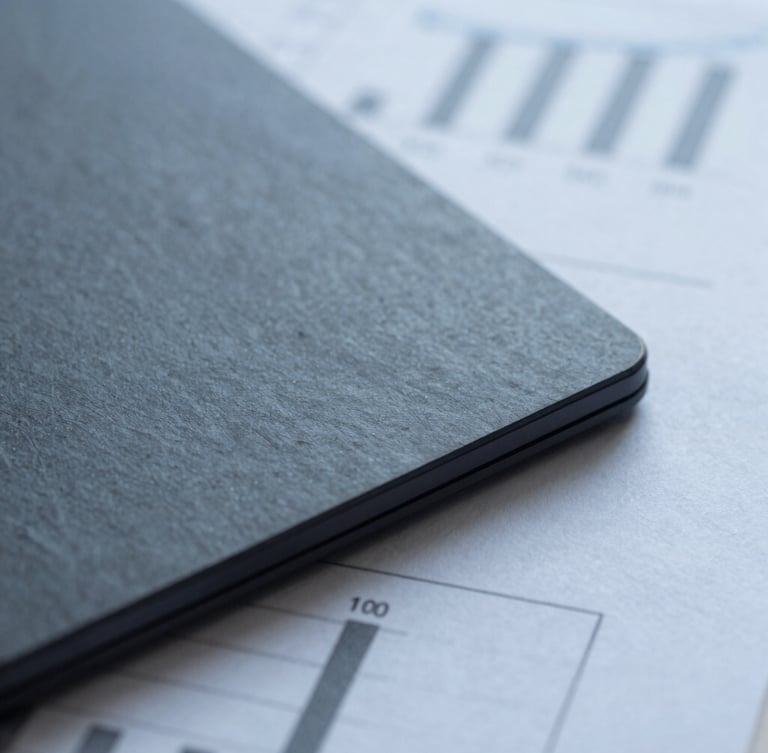 Macro detail of high-quality financial paper reports with sharp architectural shadows, cool diffused daylight, desaturated slate tones