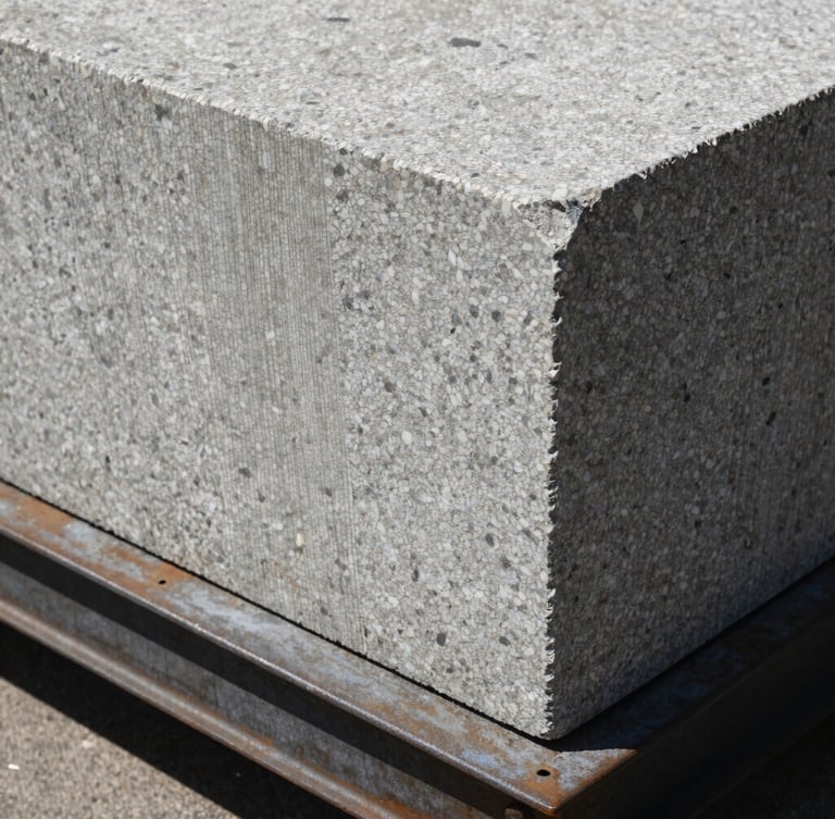 Extreme close-up of a raw granite block resting on a structural steel plate, harsh direct sunlight, high-contrast textures