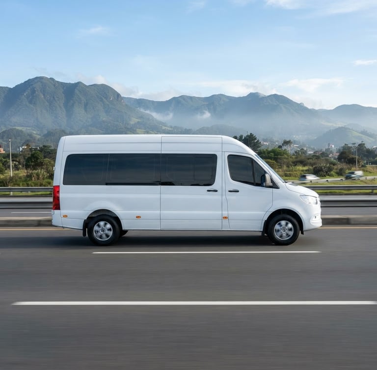 Side profile of a spotless modern executive white passenger van driving on a clean highway near Bogotá, bright morning daylight, professional editorial corporate photography style.