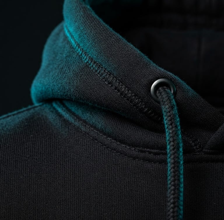 Sleek editorial product photography of a heavy cotton hoodie construction, sharp high-contrast studio lighting, vibrant cyan gel accents against deep black fabric texture, macro detail, 50mm lens