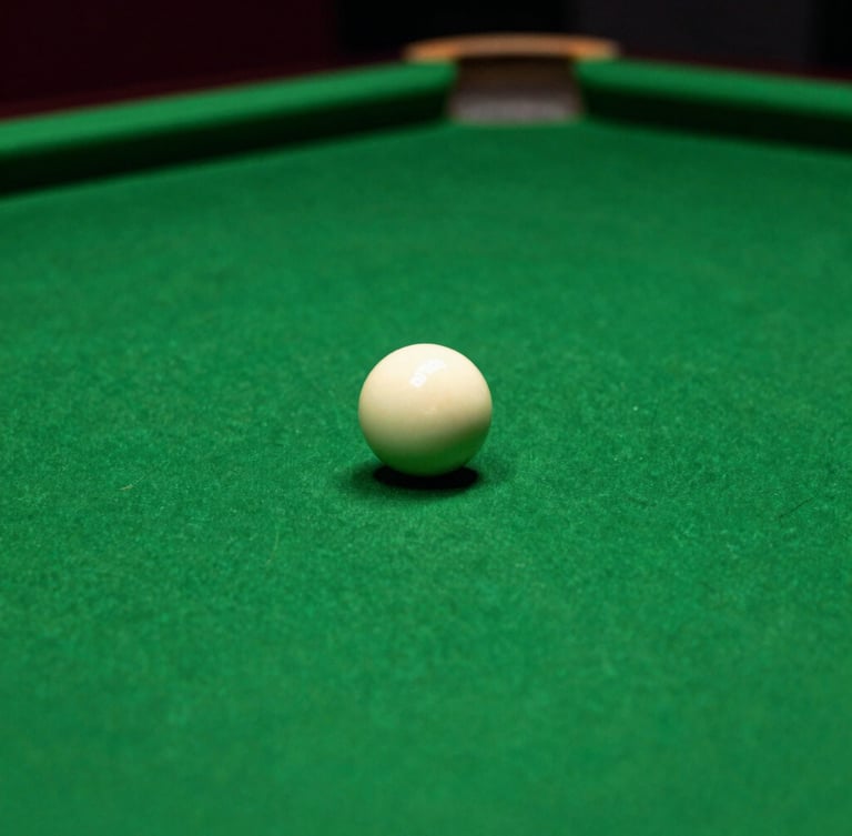 Macro shot of a pristine green billiard table, a single white cue ball in sharp focus, moody Rolex green ambient lighting, cinematic 35mm photography