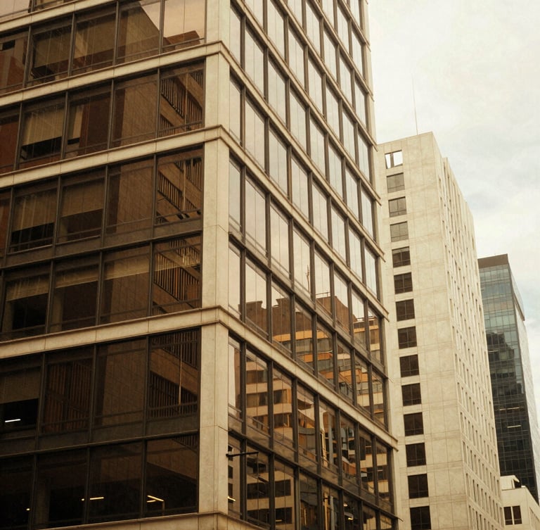 Architectural abstract of a modern Colombian business district in Bogotá, warm afternoon window light reflecting on glass, espresso and cream tones, 35mm