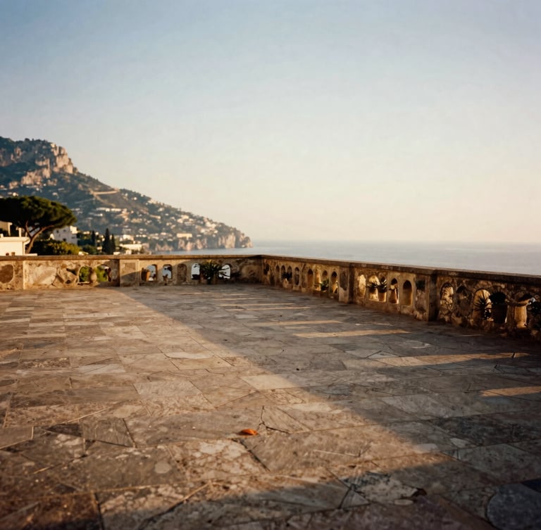 Wide environmental shot of an empty, sun-drenched stone terrace overlooking the Amalfi Coast at golden hour, no people, soft shadows, 35mm