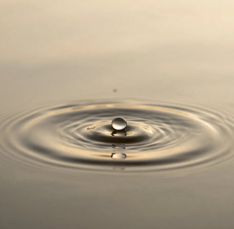 Image en portrait d'une goutte d'eau tombant dans une surface d'eau, créant des ondes concentriques parfaites, éclairée par une lumière douce et dorée. Ambiance sereine et méditative, macro-texture.