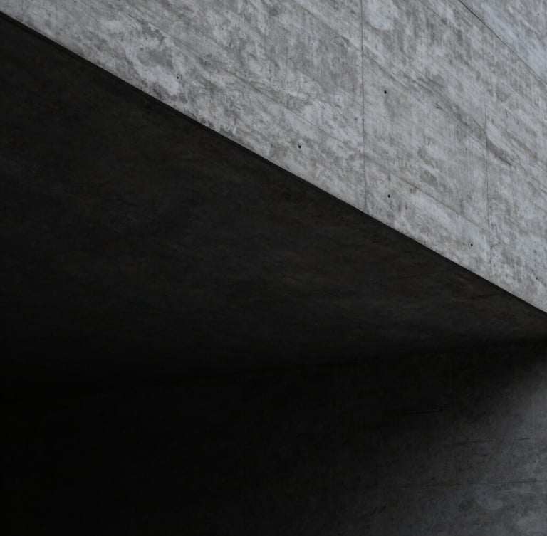 Architectural detail of a minimalist concrete structure with sharp geometric shadows, clean lines, low-key lighting