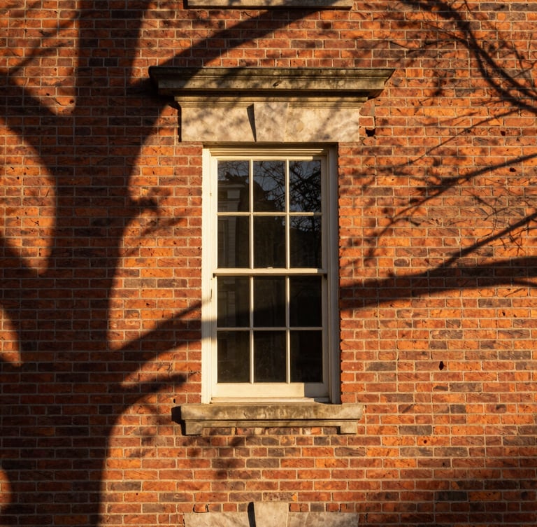 Architectural detail of a historic brick facade in Leesburg, warm morning light casting long shadows, rich textures, editorial framing