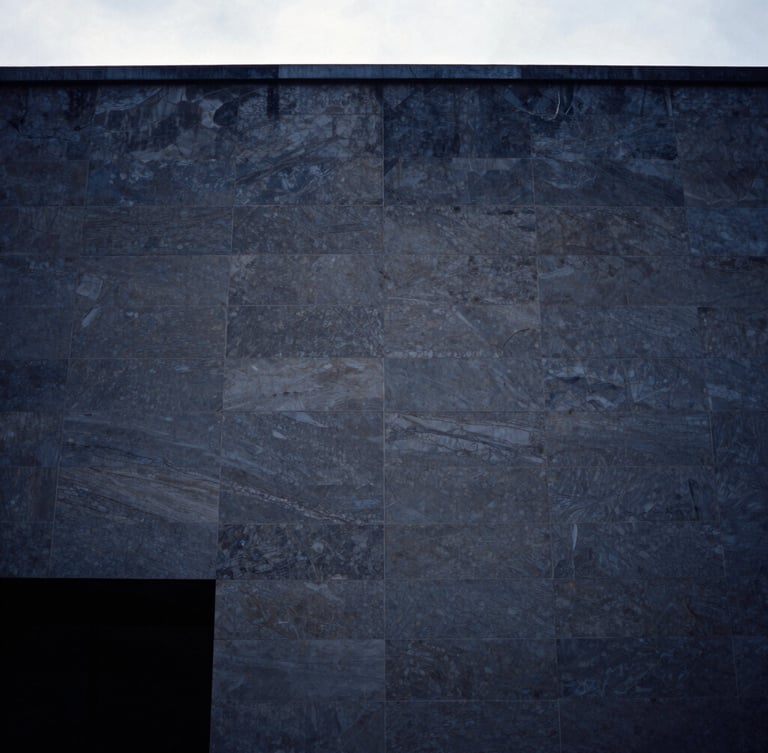 Editorial film photography, cool overcast daylight, deep navy tones, a minimalist architectural crop of a modern limestone facade in Paris, 35mm composition.