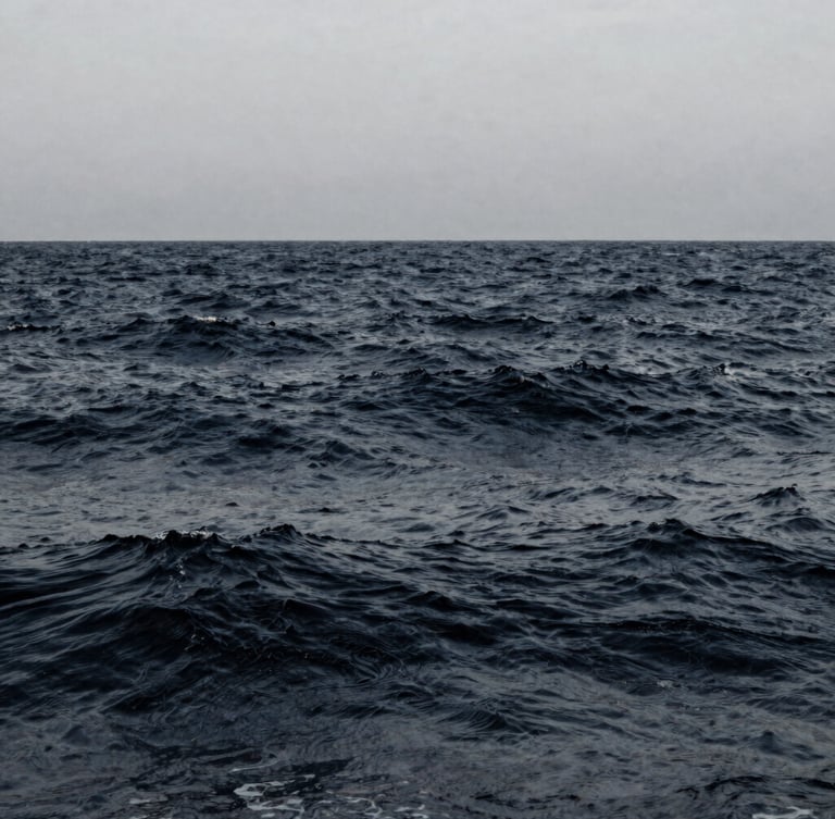 Slow-motion desaturated ocean waves, deep navy and muted slate tones, minimalist composition, 35mm film photography.
