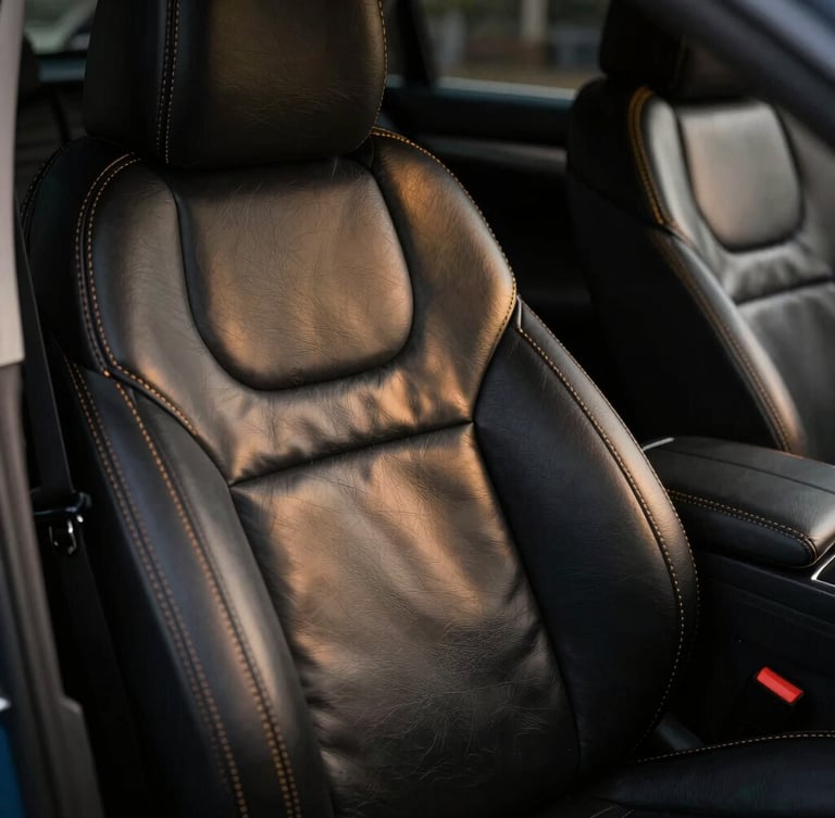 Ultra close-up of precision hand-stitched leather seat covers inside a luxury vehicle, gold contrast stitching on black leather, dramatic low-key studio lighting, sharp metallic reflections, 35mm lens