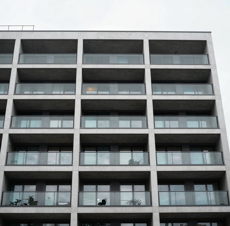 Low-angle architectural portrait of a modern multi-story residential building facade in London, clean glass balconies, crisp overcast daylight
