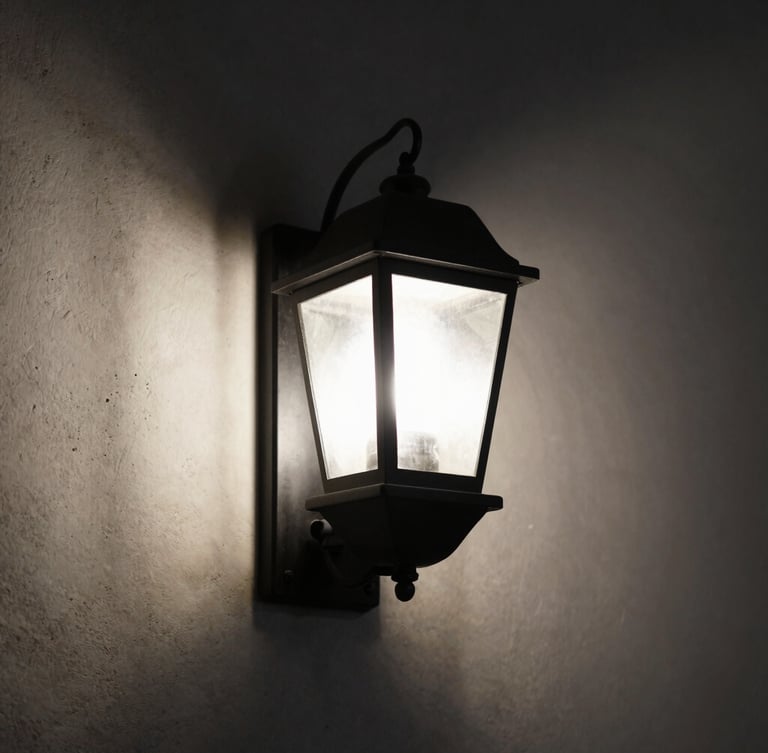 Moody close-up of a matte black iron wall lantern casting a precise, low-glare pool of light against a raw plaster wall, directional side-lighting, deep shadows, 50mm lens
