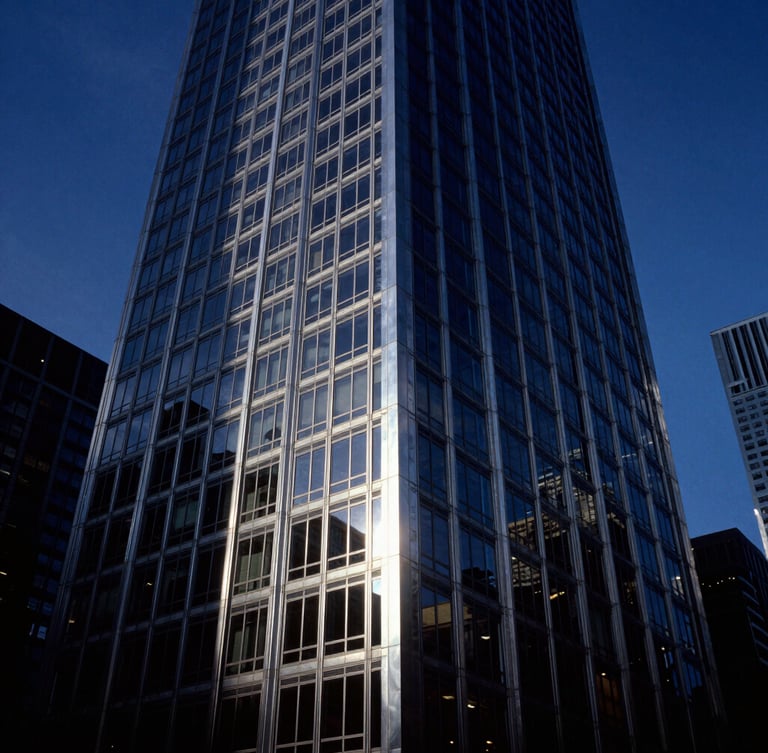 Dramatic wide-angle architectural photograph of a steel and glass Chicago skyscraper facade at blue hour, deep navy and brushed silver tones, high contrast, 35mm