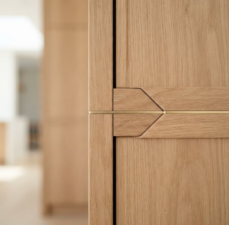 Close-up of seamless wood joinery with soft gold accents, bright natural morning light, architectural straight-on shot, shallow depth of field