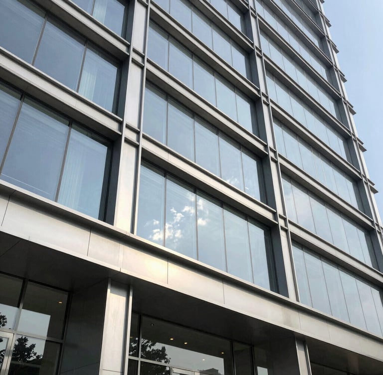 Close-up architectural detail of a premium commercial building facade in Gurgaon, steel and glass structure, bright natural daylight, sharp focus