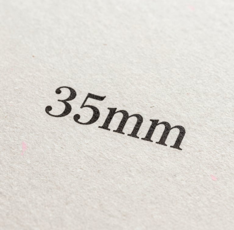 Macro shot of crisp black printed serif text on textured handmade paper, showcasing the tactile fibers of the page under soft, angled natural daylight.