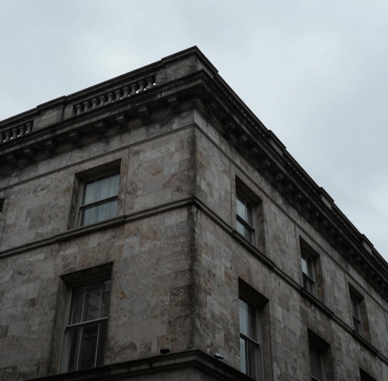 Extreme low-angle architectural crop of a Portland stone building corner against a moody overcast London sky, sharp focus