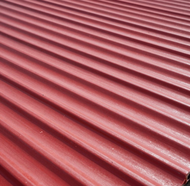 Bold industrial photography of high-contrast corrugated red steel roofing sheets under direct bright sunlight, sharp focus on metallic texture