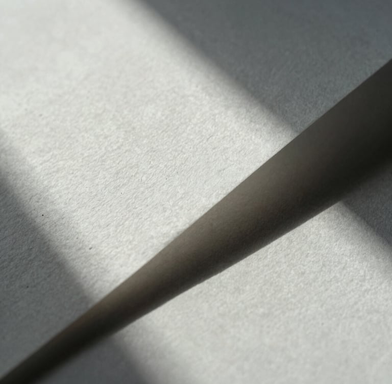 Close-up macro shot of structured heavy cotton paper with deep geometric shadows, cold natural light, minimalist and clean.