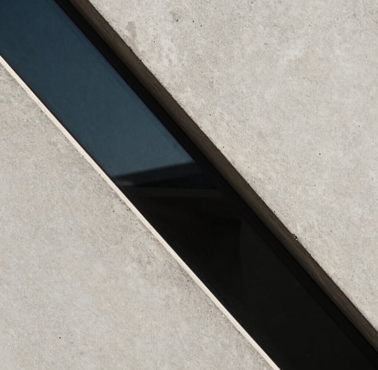 Foco macro em linhas geométricas de concreto e vidro sob luz fria de inverno, sombras marcadas e composição minimalista.