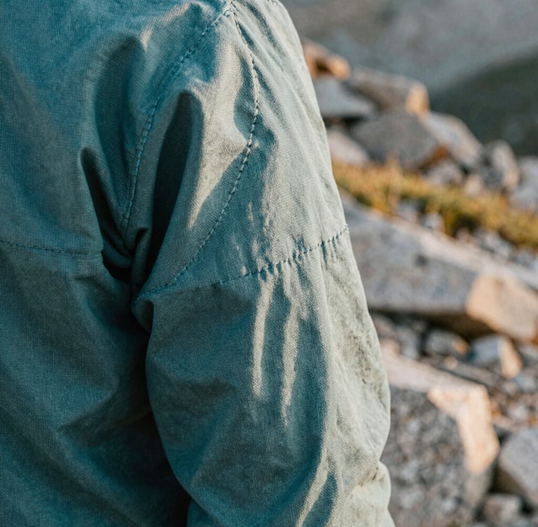 Close up of heavy-weight canvas apparel stitching, rugged texture, outdoor natural light, shallow depth of field