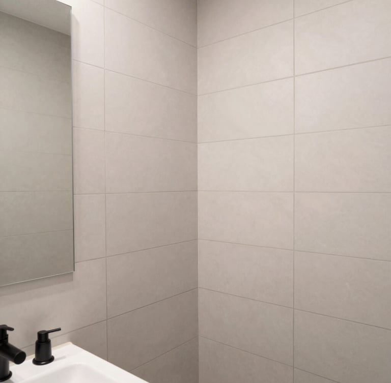Crisp architectural close-up of a newly remodeled bathroom, flawless vertical tile joints, neutral gray grout, matte black fixtures, bright natural daylight