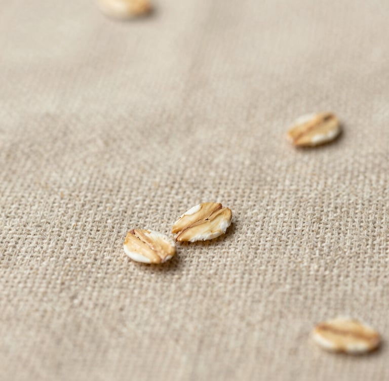 Extreme close-up of textured oatmeal linen weave, showing the beautiful imperfections of raw natural fibers in soft diffused light, warm editorial photography.