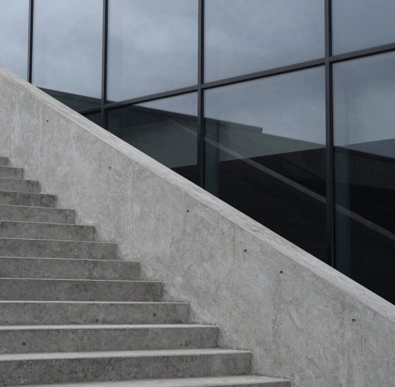 Stark, high-contrast architectural detail of concrete stairs meeting a glass wall, sharp angles, cool overcast daylight, minimalist composition, 35mm