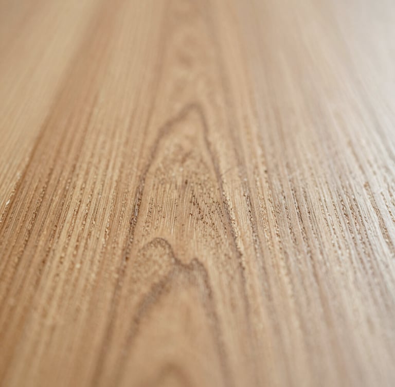 Extreme macro shot of raw hand-sanded English oak grain, soft natural side-light, shallow depth of field, warm editorial 35mm photography