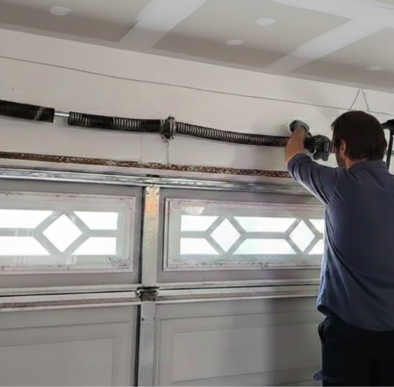 Professional technician performing a garage door spring repair on a residential overhead door.