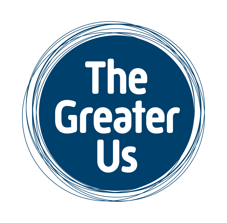 A circular blue logo with the name "The Greater Us" written inside